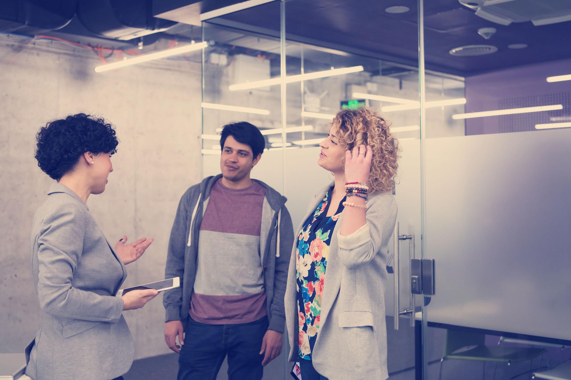 Un groupe de jeunes hommes d'affaires discutant d'un plan d'affaires dans un immeuble de bureaux de start-up moderne