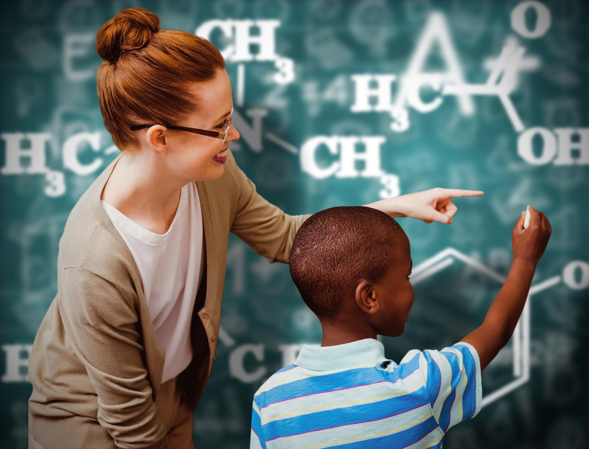 Élève et professeur heureux contre le tableau vert