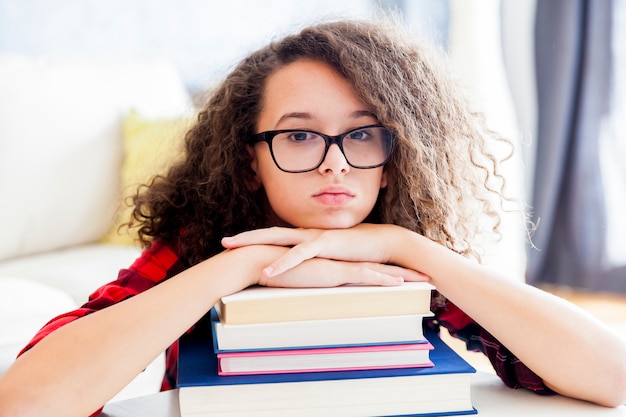 Adolescente reposant sur des livres dans la chambre