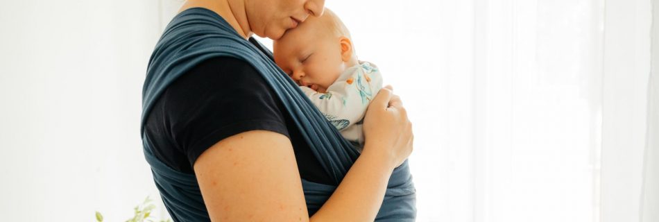 Concept parental d'attachement Jeune mère avec bébé en écharpe