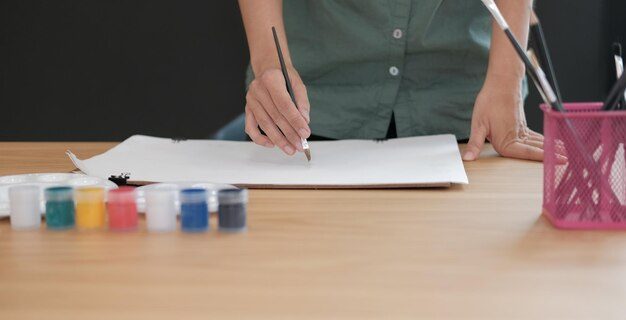 Section médiane d'une femme lisant un livre sur la table