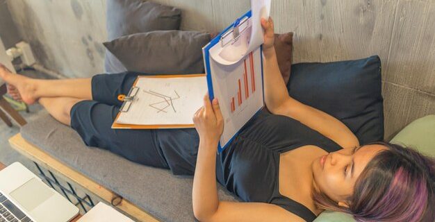 Vue haute angle d'une femme se détendant sur un livre