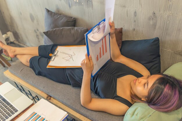 Vue haute angle d'une femme se détendant sur un livre